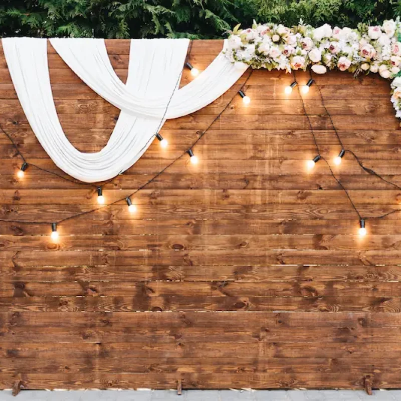 rustic-wooden-wedding-arch-with-retro-garland-decorated-with-flowers-wedding-ceremony-newlyweds
